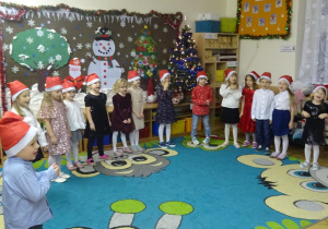 Dzieci stoją w kole i prezentują występ świąteczny.