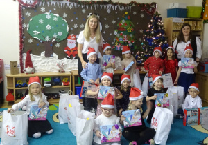 Nauczyciele i dzieci stoją obok siebie.