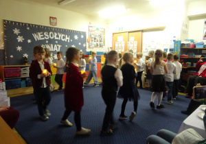 Dzieci podczas występu idą jedno za drugim.