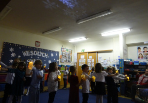 Dzieci podczas występu maszerują jedno za drugim.