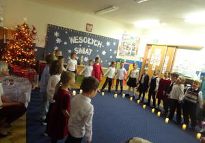 Dzieci podczas występu trzymają się za ręce.