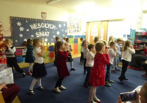 Dzieci podczas występu składają ręce przy twarzy.