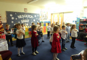 Dzieci podczas występu składają ręce na ramionach.