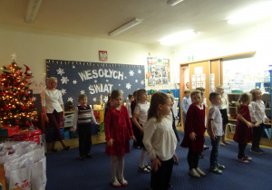 Dzieci podczas występu stoją prosto obok siebie.