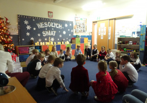 Dzieci siedzą w kole.