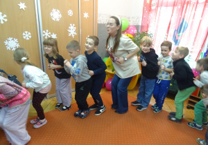 Dzieci i nauczyciele wykonują pląsy taneczne.