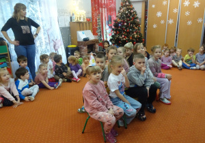 Dzieci podczas wspólnych zabaw siedzą na krzesełkach.