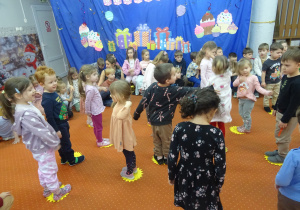 Dzieci stoją na żółtych kołach.