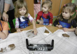 Dziewczynka wycina formę z ciasta piernikowego.