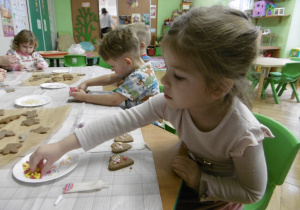 Dziewczynka dekoruje ciastko.