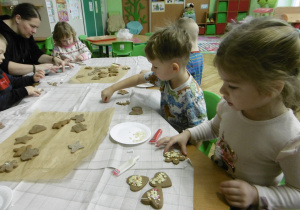 Grupa dzieci dekoruje ciastka.