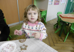 Dziewczynka podczas dekorowania ciastka.