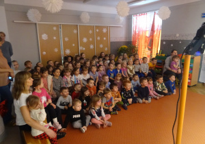 Dzieci siedzą na widowni i ogladają przedstawienie.