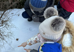 Dzieci wskazują na leżącą gałązkę.