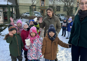 Grupa dzieci stoi razem w grupie podczas zimowego wyjścia.