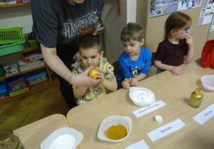 Nauczycielka podaje dziecku cytrynę.