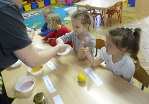 Dzieci dotykają mąkę ziemniaczaną.