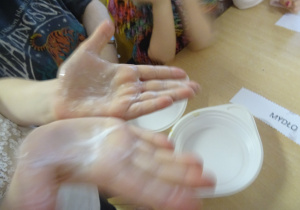 Dłonie dziecka ubrudzone mąką.