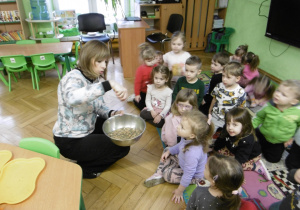 Nauczycielka pokazuje dzieciom nasiona.