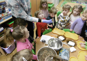 Dzieci przyglądają się kulce zrobionej z nasion.