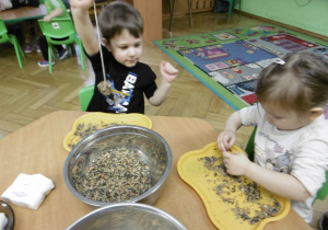 Chłopiec podnosi wysoko rękę z wykonaną przez siebie pracą.