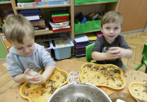 Dwóch innych chłopców wykonuje kulki z nasion.