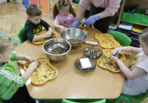 Grupa dzieci siedzi przy stoliku.