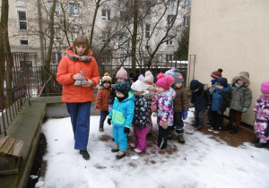Nauczycielka i dzieci stoją na tarasie przedszkolnym.