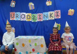 Dzieci siedzą przy stoliku.