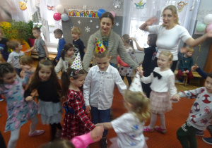 Dzieci tańczą w kółku.