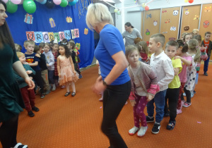 Grupa dzieci idzie jedno za drugim.