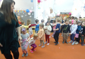 Dzieci podczas wspólnej zabawy idą jedno za drugim.