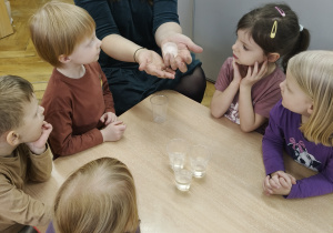Nauczycielka pokazuje w dłoniach białą kulkę.
