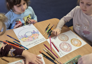 Dwie dziewczynki siedzą przy stoliku.