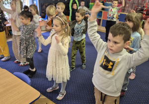 Inna grupa dzieci podczas zabaw tanecznych w sali przedszkolnej.