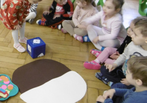 Dziewczynka stoi przy kostce do rzucania.