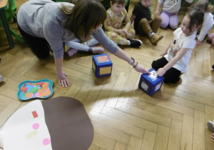 Nauczyciel wskazuje palcem kostkę do rzucania.