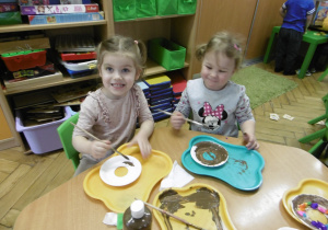 Dwie dziewczynki siedzą obok siebie.