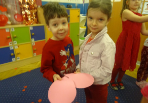 Dwoje dzieci stoi obok siebie.