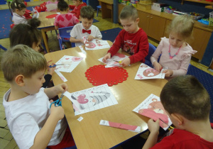 Grupa dzieci siedzi przy stoliku.