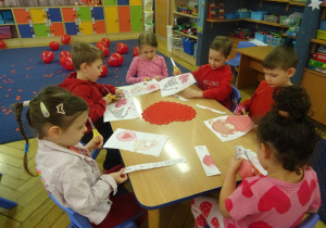 Inna grupa dzieci siedzi przy stoliku.