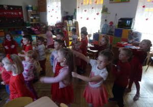 Grupa dzieci tańczy przy tablicy interaktywnej.