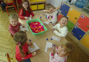 Grupa dzieci siedzi przy stoliku.