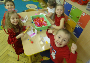 Inna grupa dzieci siedzi przy stoliku.