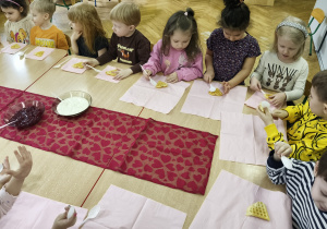 Inna grupa dzieci siedzi przy stole.