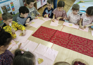 Dzieci smarują gofry powidłami.