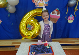 Jedna solenizantka stoi przy cieście.