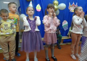 Dzieci stoją obok siebie.