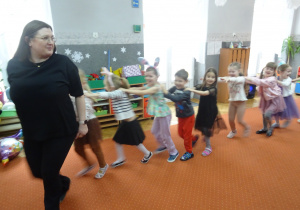 Nauczycielka prowadzi grupę dzieci.