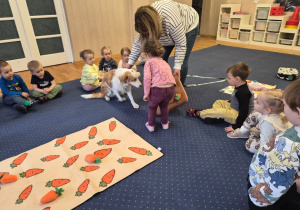 Dziewczynka schyla się do pieska.